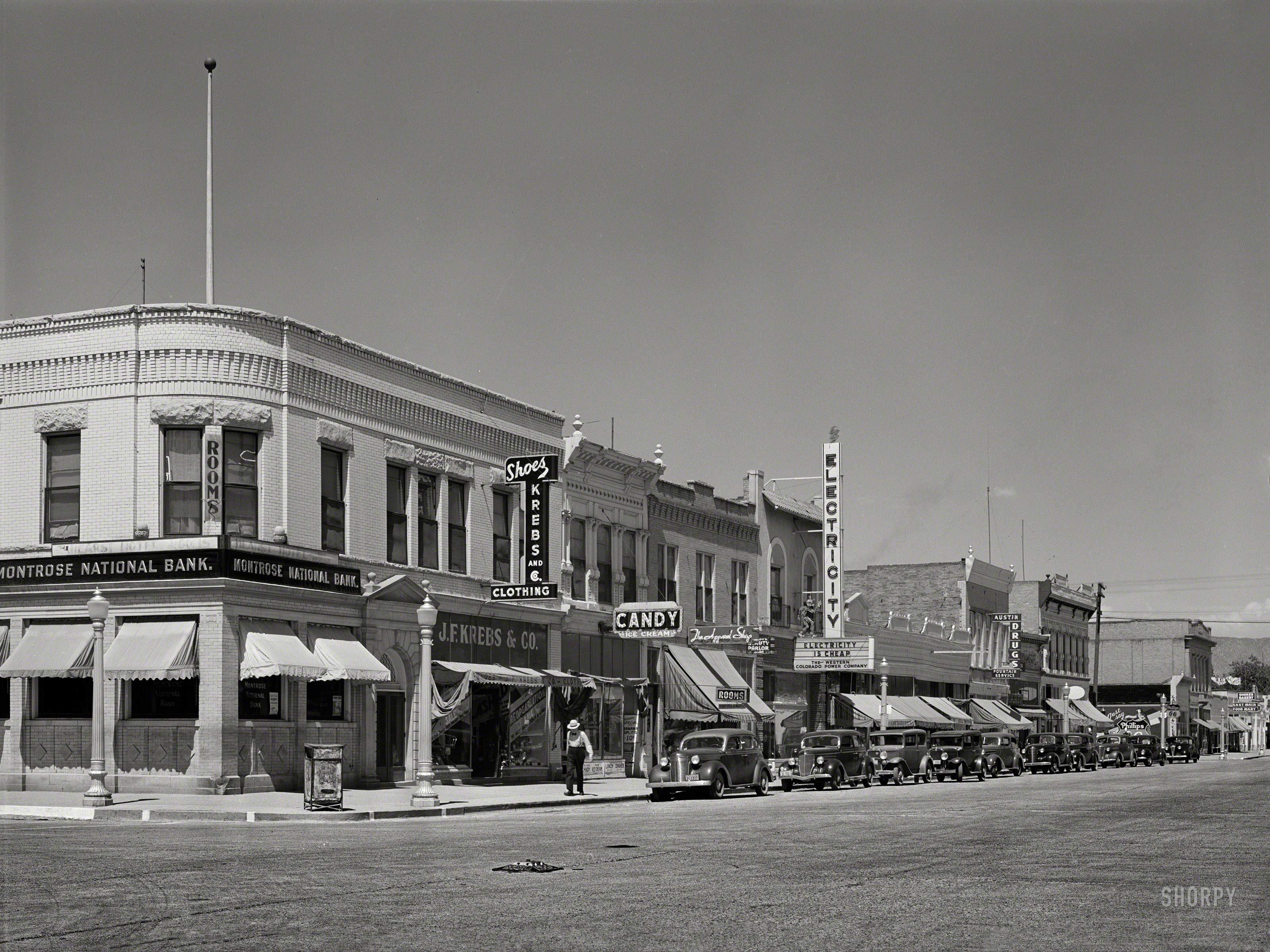 September 1940. "Main street in Montrose, Colorado." Special guest appearance by Reddy Kilowatt. Medium format negative by Russell Lee. View full size.