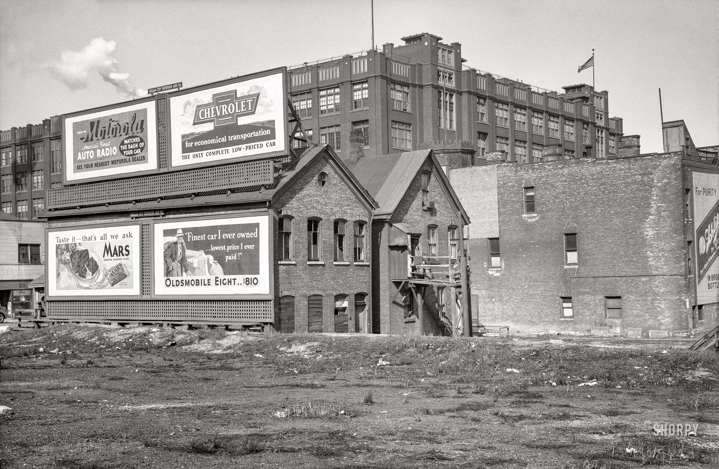 April 1936. "Rear of houses at 711 West State Street. Milwaukee Vocational School in background." Photo by Carl Mydans for the Resettlement Administration. View full size.
