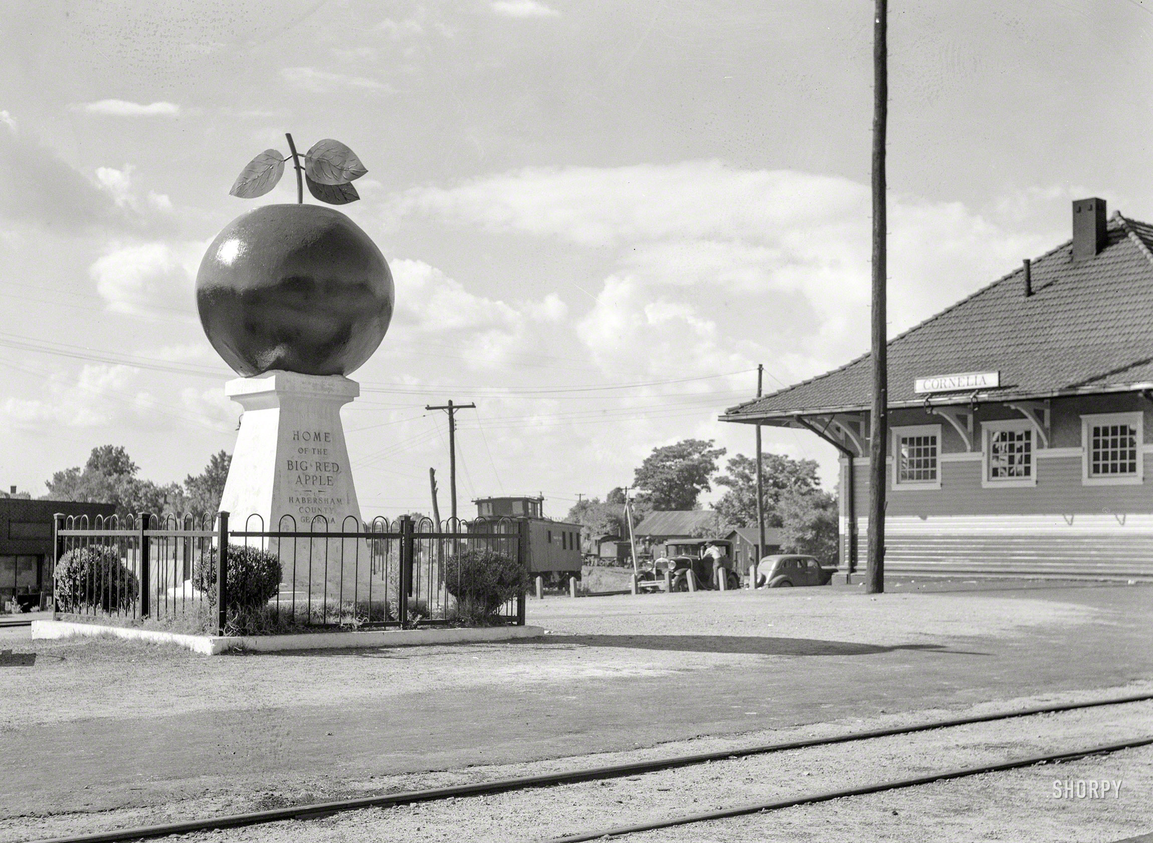 June 1936. "Apple monument at depot of Cornelia, Georgia." Medium format negative by Carl Mydans for the Farm Security Administration. View full size.