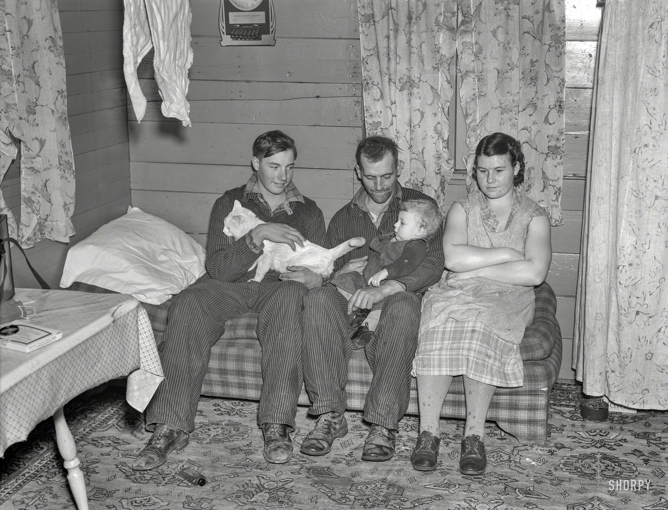 December 1936. "William Helmke, wife, baby, and brother live in one-room shack on ninety-acre farm near Dickens, Iowa, owned by lawyer." Medium format negative by Russell Lee for the Resettlement Administration. View full size.