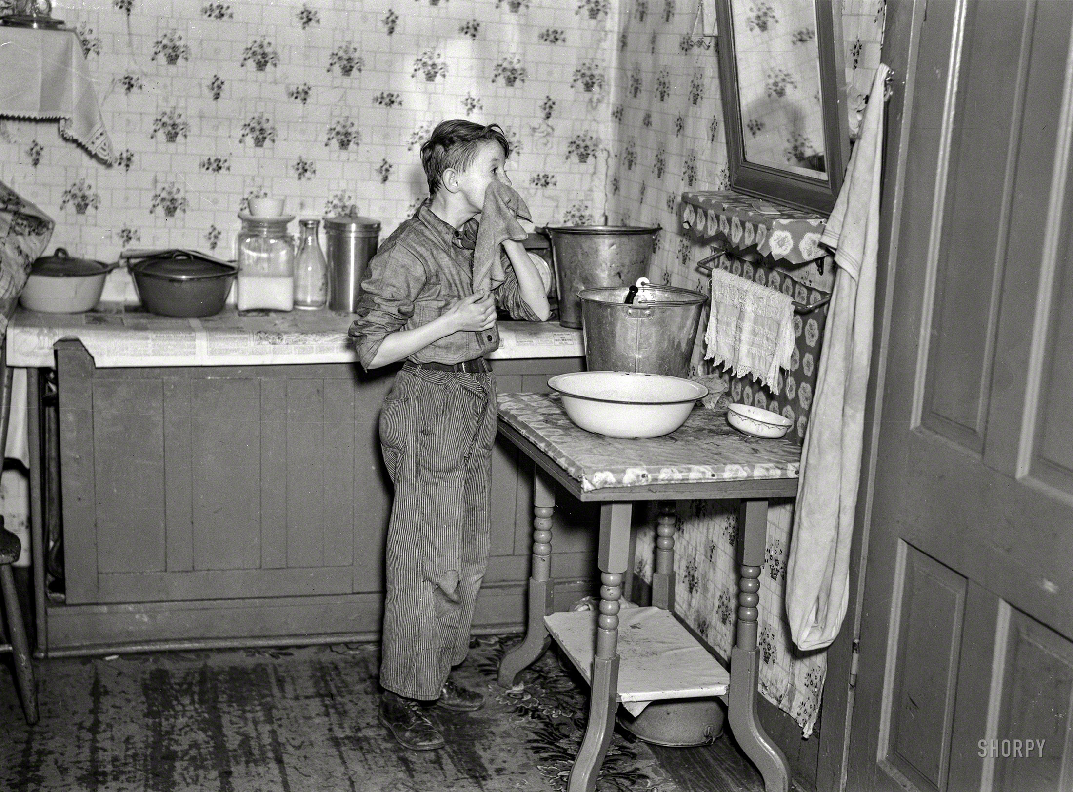 March 1937. "6:45 a.m. -- One of nine children, son of hired man Tip Estes washing his face after doing his early-morning chores. Near Fowler, Indiana." Photo by Russell Lee for the Resettlement Administration. View full size.