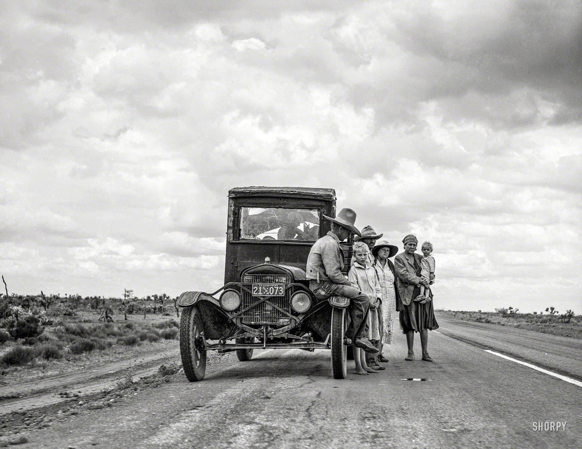 May 1937. "One of three related Oklahoma drought refugee families on the highway near Lordsburg, New Mexico, going to Roswell to chop cotton." Photo by Dorothea Lange for the Resettlement Administration. View full size.