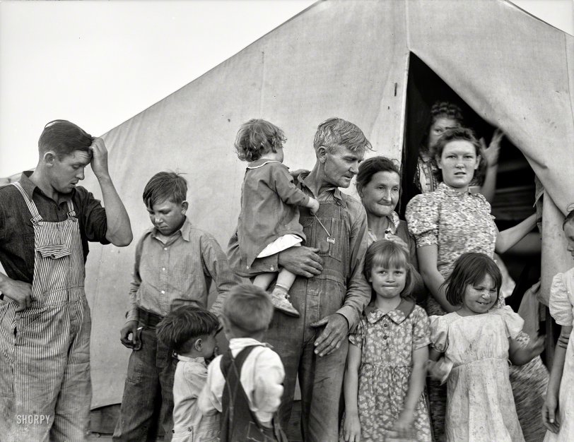 February 1939. Brawley, Imperial County, California. "In Farm Security Administration migrant labor camp during pea harvest. Family from Oklahoma with eleven children. Father, eldest daughter and eldest son working. She: 'I want to go back to where we can live happy, live decent, and grow what we eat.' He: 'I've made my mistake and now we can't go back. I've got nothing to farm with'." Photo by Dorothea Lange for the Farm Security Administration. View full size.
