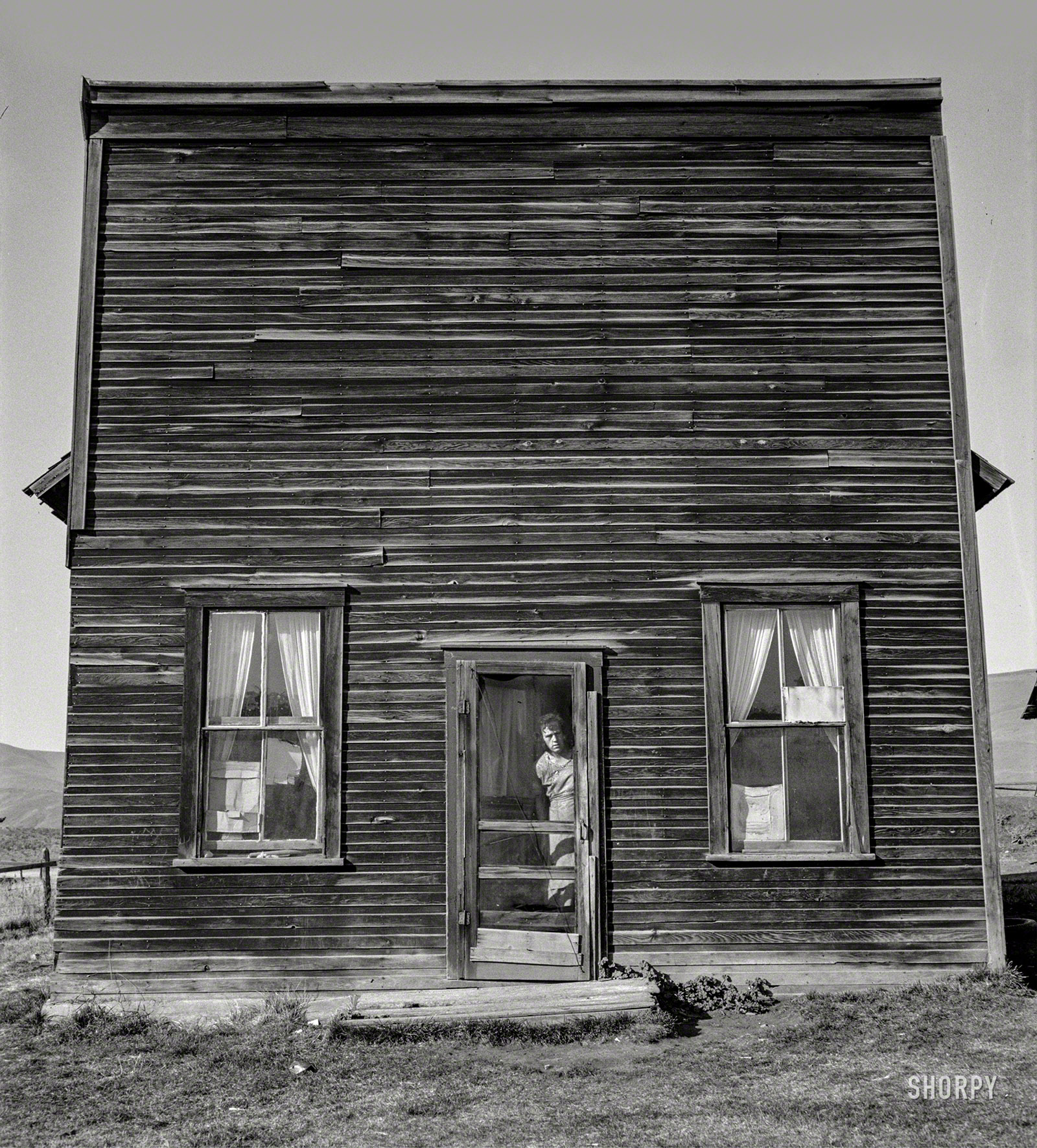 October 1939. Gem County, Idaho. "Member of Ola self help sawmill co-op lives in what was once the 'Jackknife Saloon.' This type building is characteristic of early Idaho. The stagecoach used to stop here to change horses and for the refreshment of travelers. This was discontinued in 1914." Medium format nitrate negative by Dorothea Lange for the Farm Security Administration. View full size.