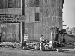 &nbsp; &nbsp; &nbsp; &nbsp; "40 cents no less."
June 1937. "Packing company strike. Cambridge, Maryland." Medium format negative by Arthur Rothstein, Farm Security Administration. View full size.
A ration of PhillipsSince Delmarva farms grew tremendous amount of varied vegetables, Phillips Packing was a huge supplier of WWII rations for the troops. Now, it's almost all soybeans and corn, which we turn into chickens via Perdue and others. The packing house complex sprawled over a wide area of Cambridge. There are current plans to revitalize the remaining building.
From Packing House to Bargain CenterThe Phillips Packing warehouse survives as Artwell's Home Furnishings and Bargain Center, 1 Washington Street.  Faint lettering above "Phillips" over the warehouse door is still visible in Google Street View.  Railroad track is visible but no longer used and a water tower similar to the one shown here is also visible. Across the street is the footprint of a vary large demolished industrial complex. 
(The Gallery, Arthur Rothstein, Industry & Public Works)