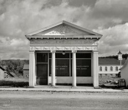 August 1937. "Closed bank, northern Minnesota town." Continuing our tour of St. Louis County. Photo by Russell Lee for the Resettlement Admin. View full size.
Tower, MNThis bank was part of the St Louis Park State Bank and the scandal that ensued. The bank is gone or remodeled to be no longer recognized but the church you see behind it remains. It looks like Roy Quimby (founder) liked the building design and used it more than once. Nice SHORPY watermark across the facade.   
http://slphistory.org/st-louis-park-state-bank/ 

(The Gallery, Russell Lee, Small Towns)