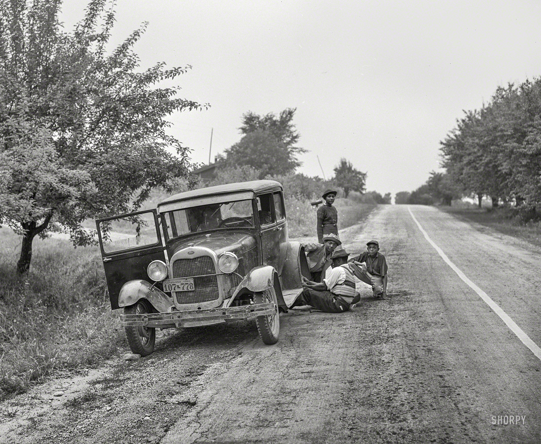 July 1940. "Migrant fruit workers from Louisiana fixing flat tire along the road. Berrien County, Michigan." Medium format acetate negative by John Vachon for the Farm Security Administration. View full size.