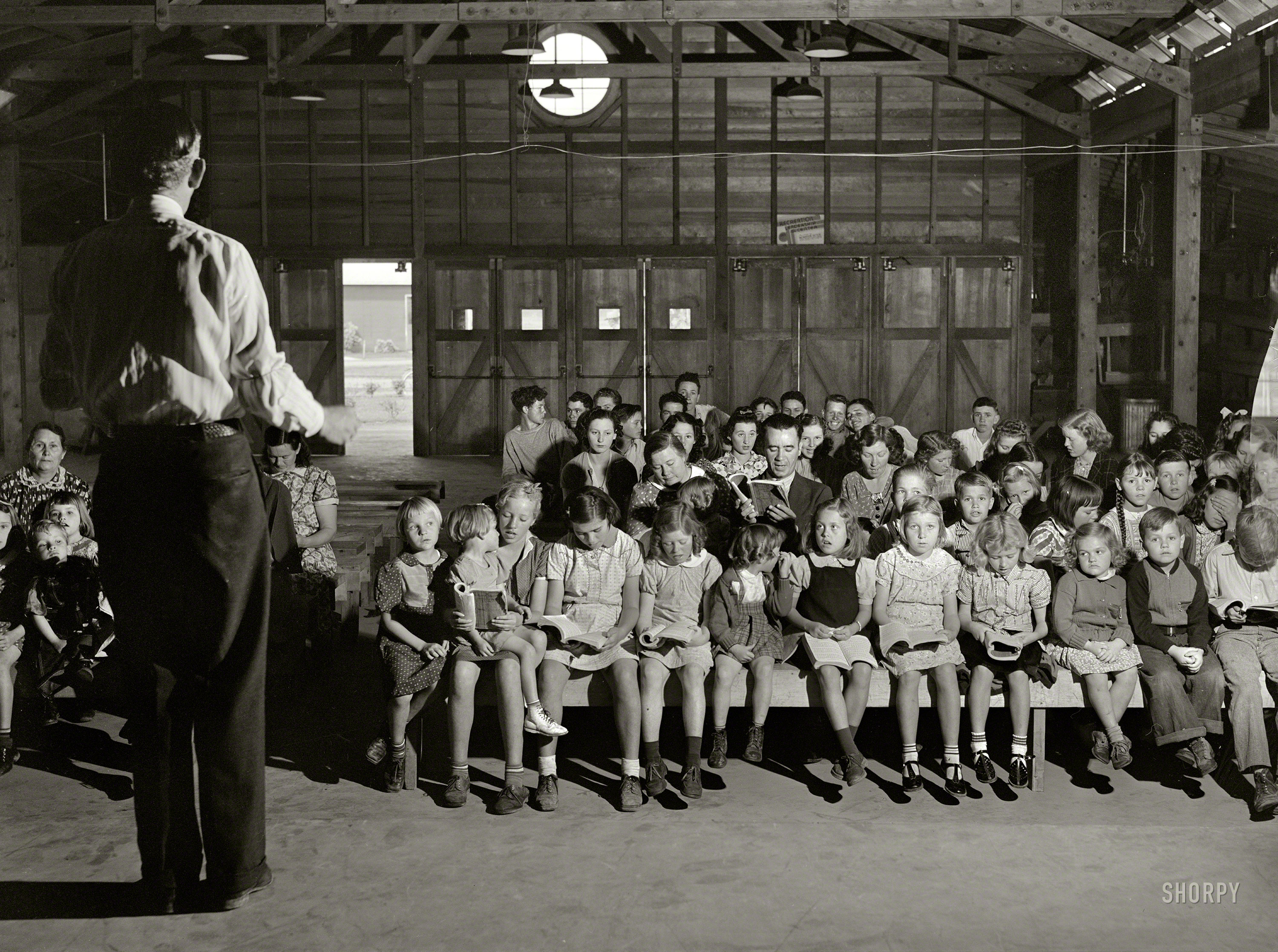 March 1940. Visalia, California. "Tulare migrant camp. Sunday school." Where the angels get to sit up front. Photo by Arthur Rothstein. View full size.