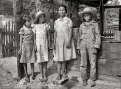 June 1936. " 'Griffin children' of Alabama land use demonstration project near Greensboro. They are all third or fourth generation resulting from, it is believed, a white woman and a Negro. They are mostly white and refused to be placed with the Negroes, but the whites will not have them. Note carefully the closeup of the four children; all are from the same family and yet differ greatly in appearance." Photo by Carl Mydans for the Resettlement Administration. View full size.