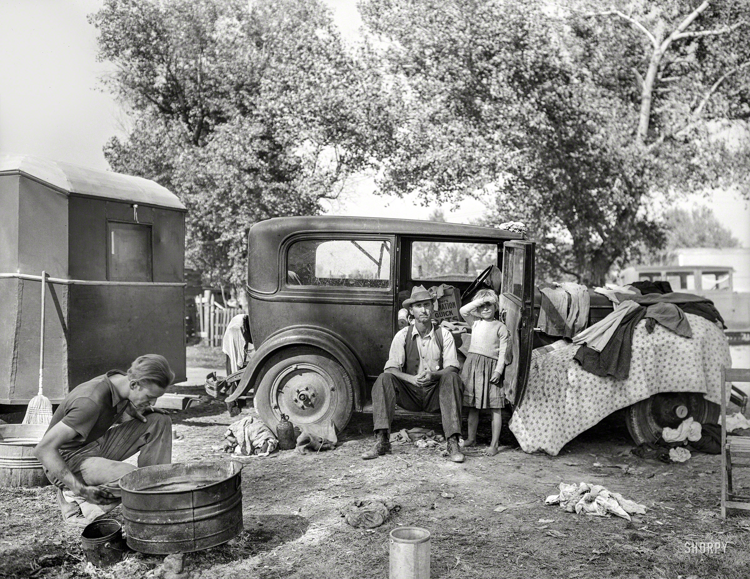 November 1936. "Migratory family in automobile camp, California." Photo by Dorothea Lange for the Farm Security Administration. View full size.
