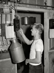 November 1940. "Tulare County, California. Son of worker weighing up milk at Mineral King cooperative farm. Accurate milk records of each cow are kept." Photo by Russell Lee for the Farm Security Administration. View full size.