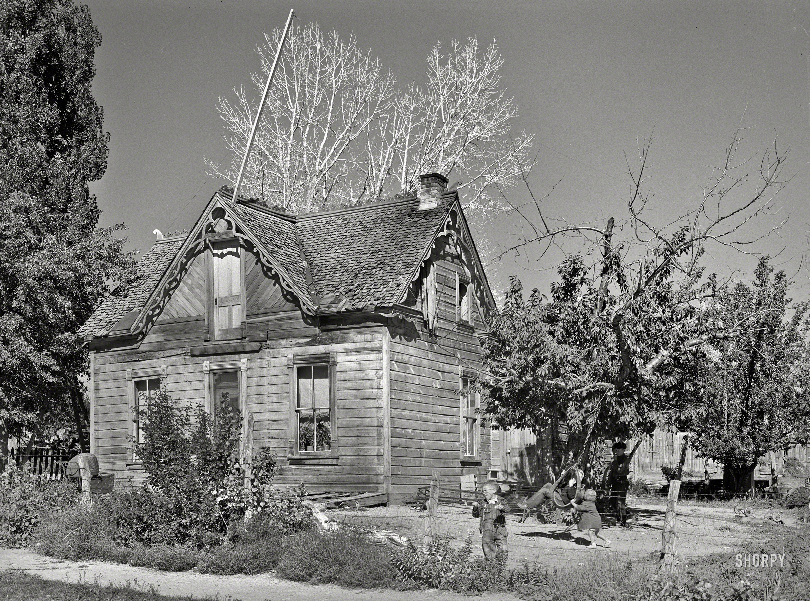 November 1940. "Children in yard of old Mormon house at Tropic, Utah." Photo by Russell Lee for the Farm Security Administration. View full size.