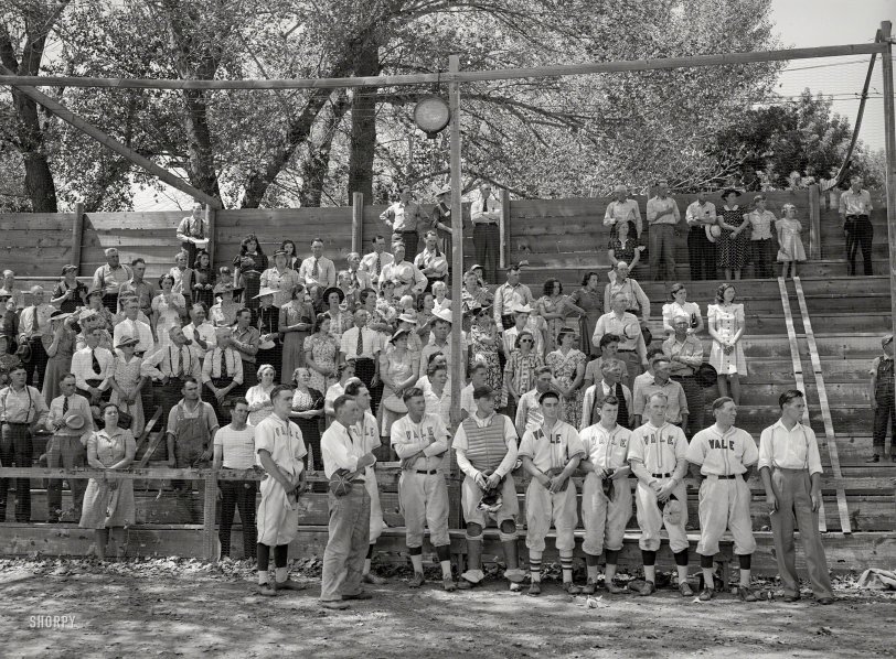 July 1941. Vale, Oregon. "Baseball players and spectators stand at attention while Chief Justice Stone gives the oath of allegiance over the radio." Medium format negative by Russell Lee for the Farm Security Administration. View full size.
