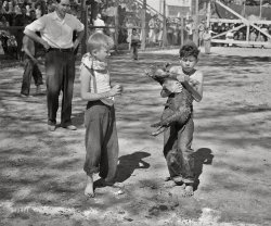 1941. "Boy who caught the greased pig at the Fourth of July celebration at Vale, Oregon. Says he's going to join the 4-H Club so he can learn how to feed his pig properly." Photo by Russell Lee, Farm Security Administration. View full size.