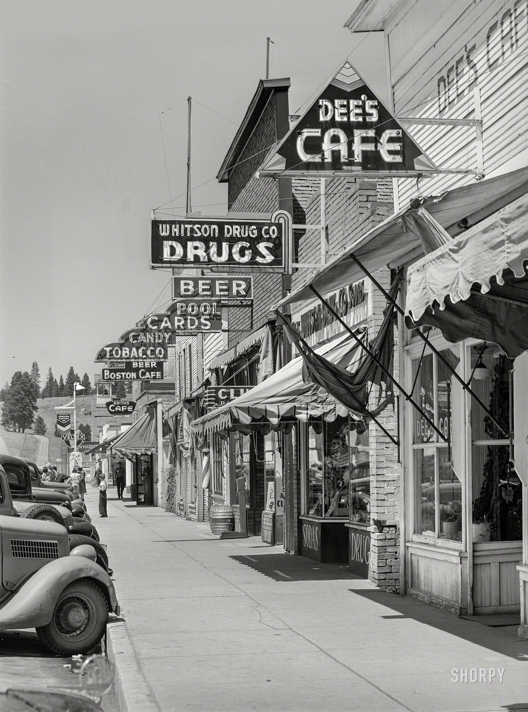 June 1941. "Street scene in Cascade, Idaho. Cascade is a microcosm of Idaho's past and present -- all the industries of the state, including lumbering, mining, agriculture, stock raising and tourist trade, are apportioned to this town and its valley." Medium format acetate negative by Russell Lee. View full size.