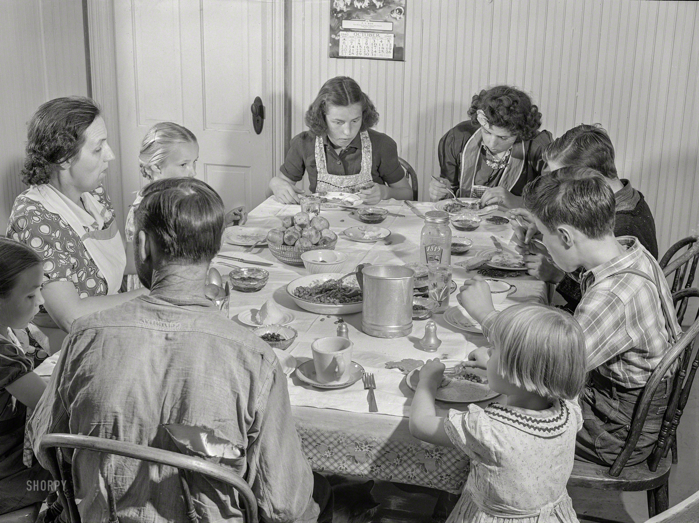 October 1940. "Dinner hour at the home of Mr. J.H. Dube, French-Canadian potato farmer, after he and the boys had finished a day's work in their potato field in Wallagrass, Maine." Medium format negative by Jack Delano for the Farm Security Administration. View full size.