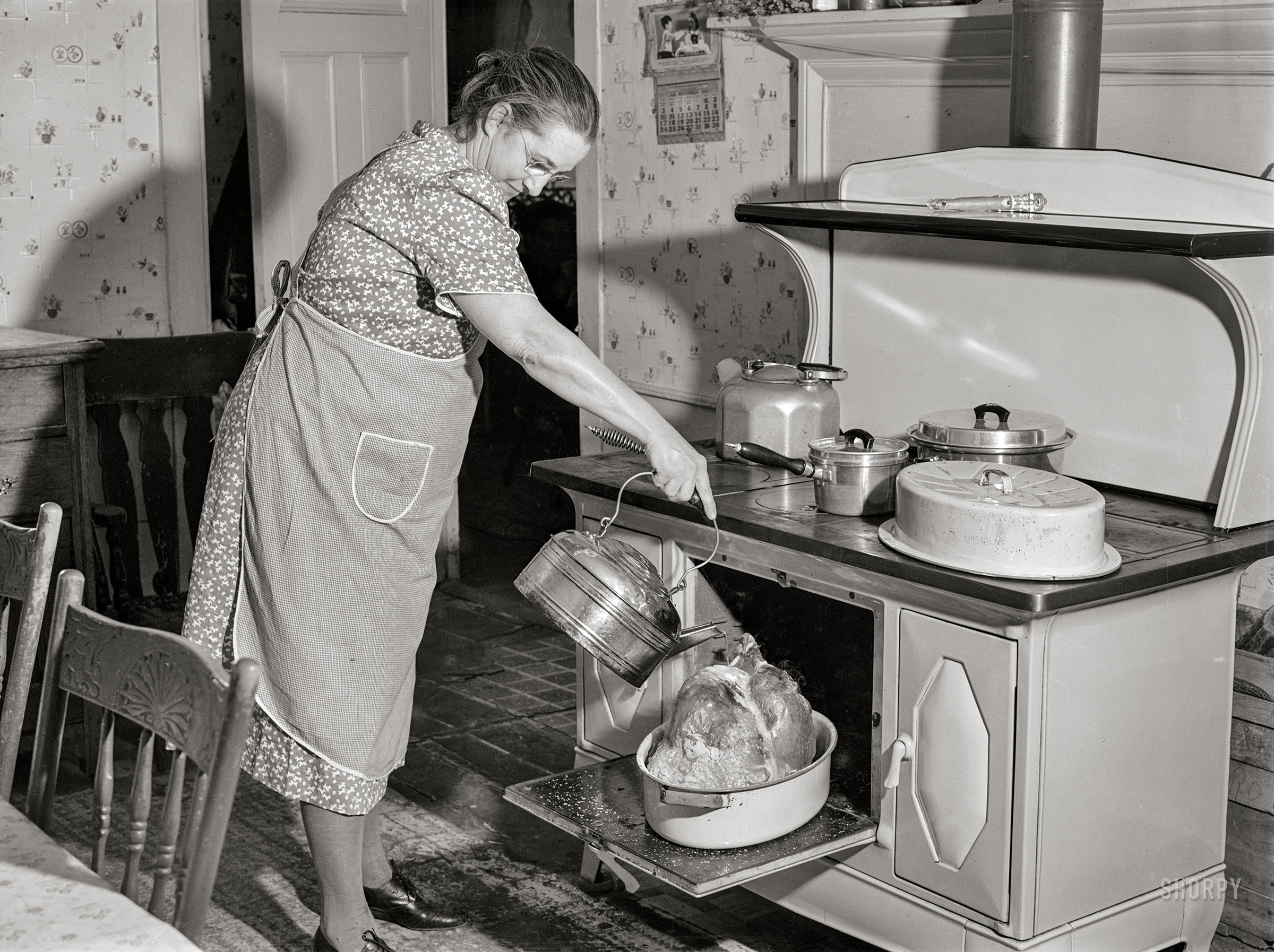 November 28, 1940. "Mrs. T.L. Crouch, of Ledyard, Connecticut, pouring some water over her twenty-pound turkey on Thanksgiving Day." Happy Thanksgiving from Shorpy! Medium format acetate negative by Jack Delano for the Farm Security Administration. View full size.