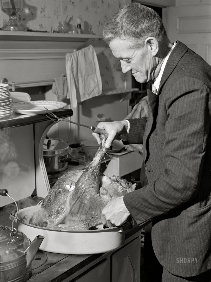 November 1940. "Ledyard, Connecticut. Mr. T.L. Crouch, a Rogerine Quaker, preparing to carve the Thanksgiving turkey." Photo by Jack Delano for the Farm Security Admin. View full size.
