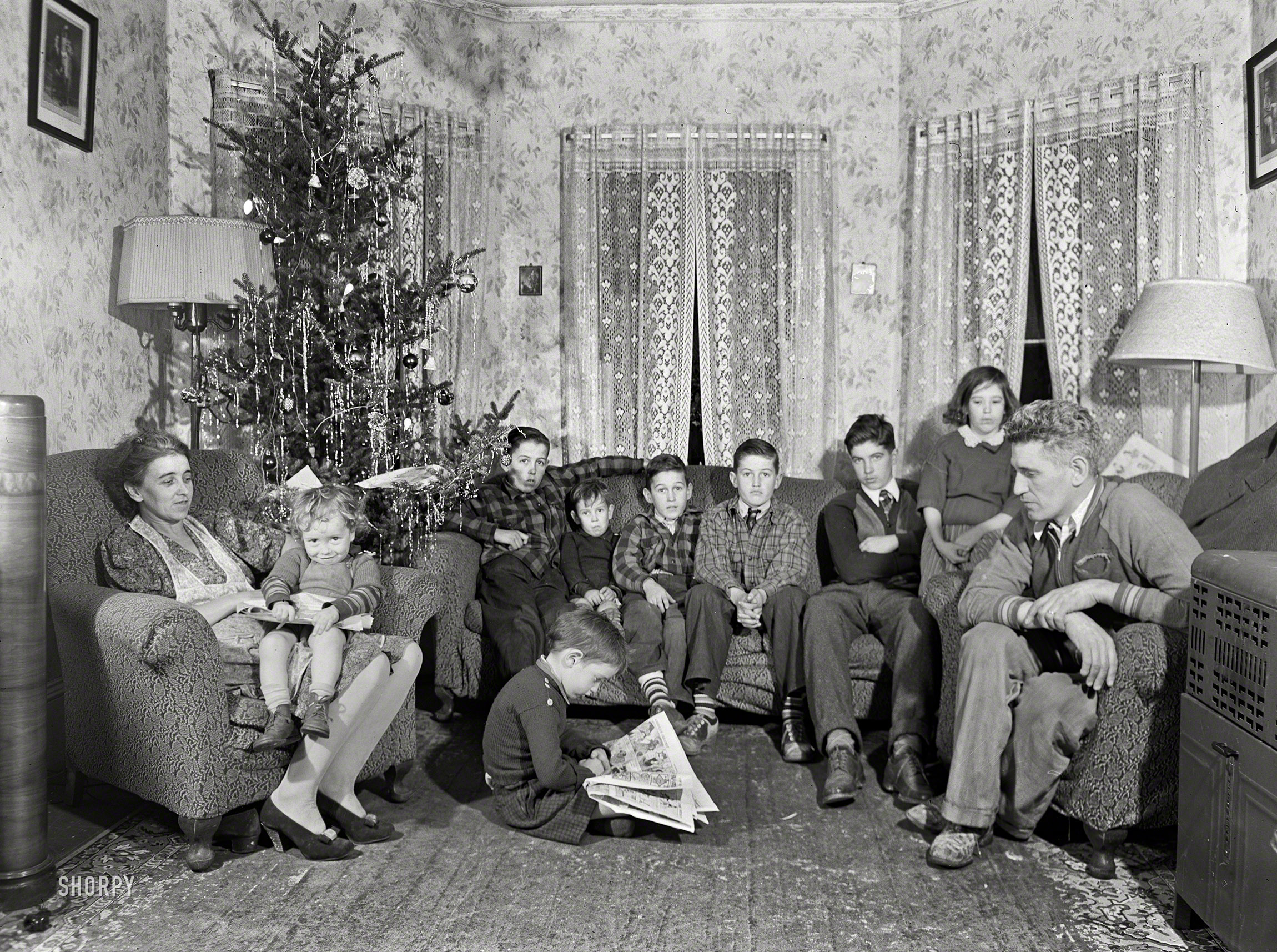 December 1940. "The family of John Kelly, who works in the Navy yard in South Boston. Their present tenement in Quincy is completely inadequate. They have been unable to move because every real estate agent has turned him down, claiming there was no reason why they should rent to large families when there is such a great demand for decent houses by hundreds of incoming shipyard workers." Medium format negative by Jack Delano. View full size.