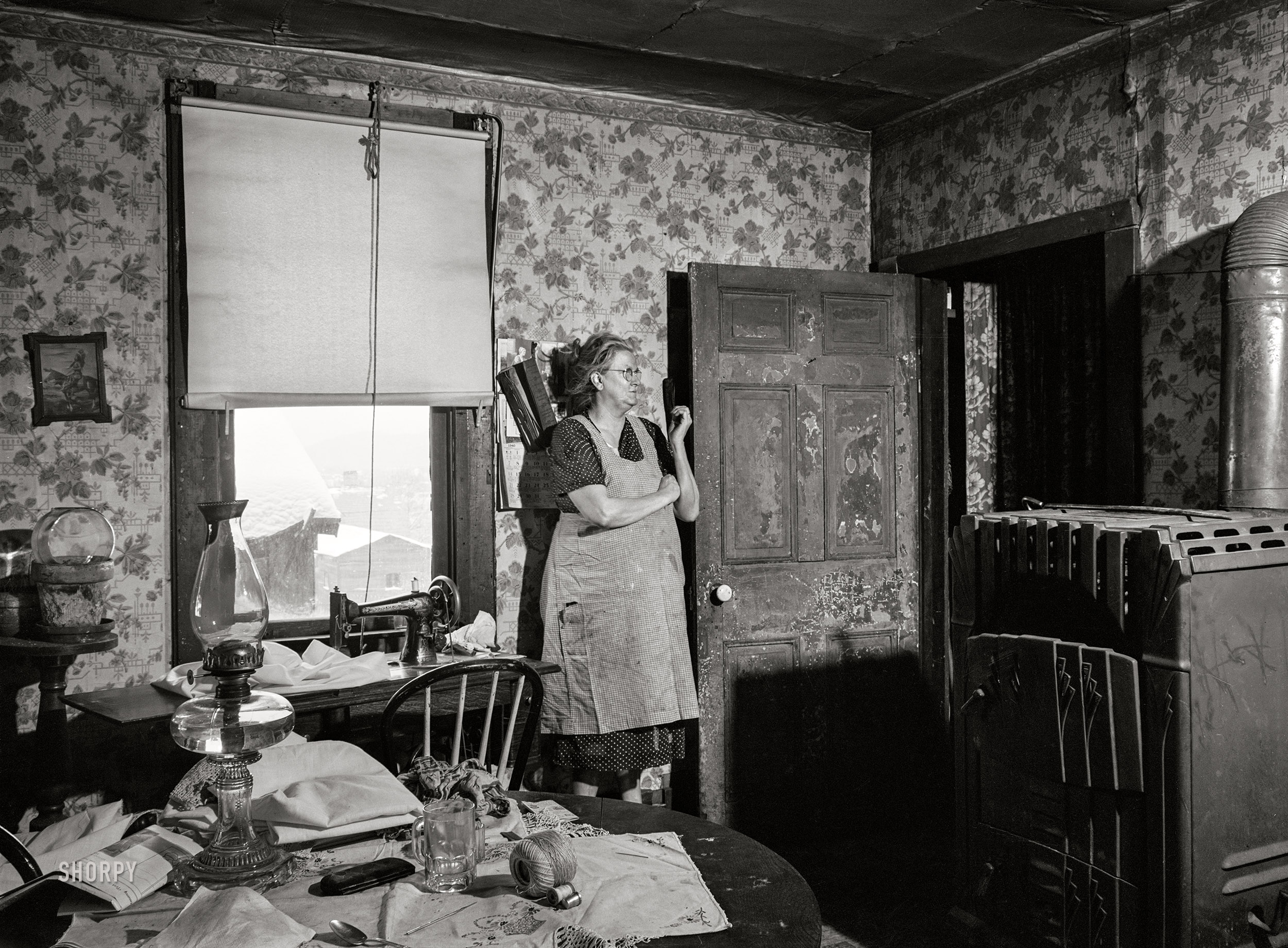 January 1940. "Woman in dilapidated old house in the Mount Washington district of Beaver Falls, Pennsylvania. She is blind in one eye and her other one is going bad too. She expressed the hope that she would lose her sight completely so she could get some money from blind pension." Medium format acetate negative by Jack Delano. View full size.