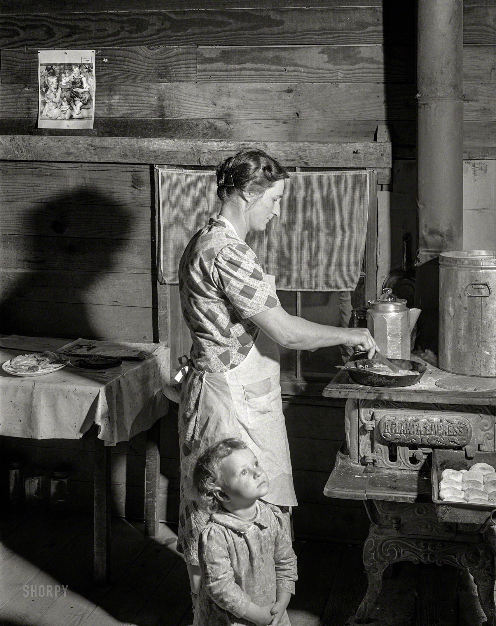 April 1941. "Mrs. Lemuel Smith, wife of Farm Security Administration borrower, preparing the afternoon meal on her farm in Carroll County, Georgia." Medium format acetate negative by Jack Delano for the FSA. View full size.