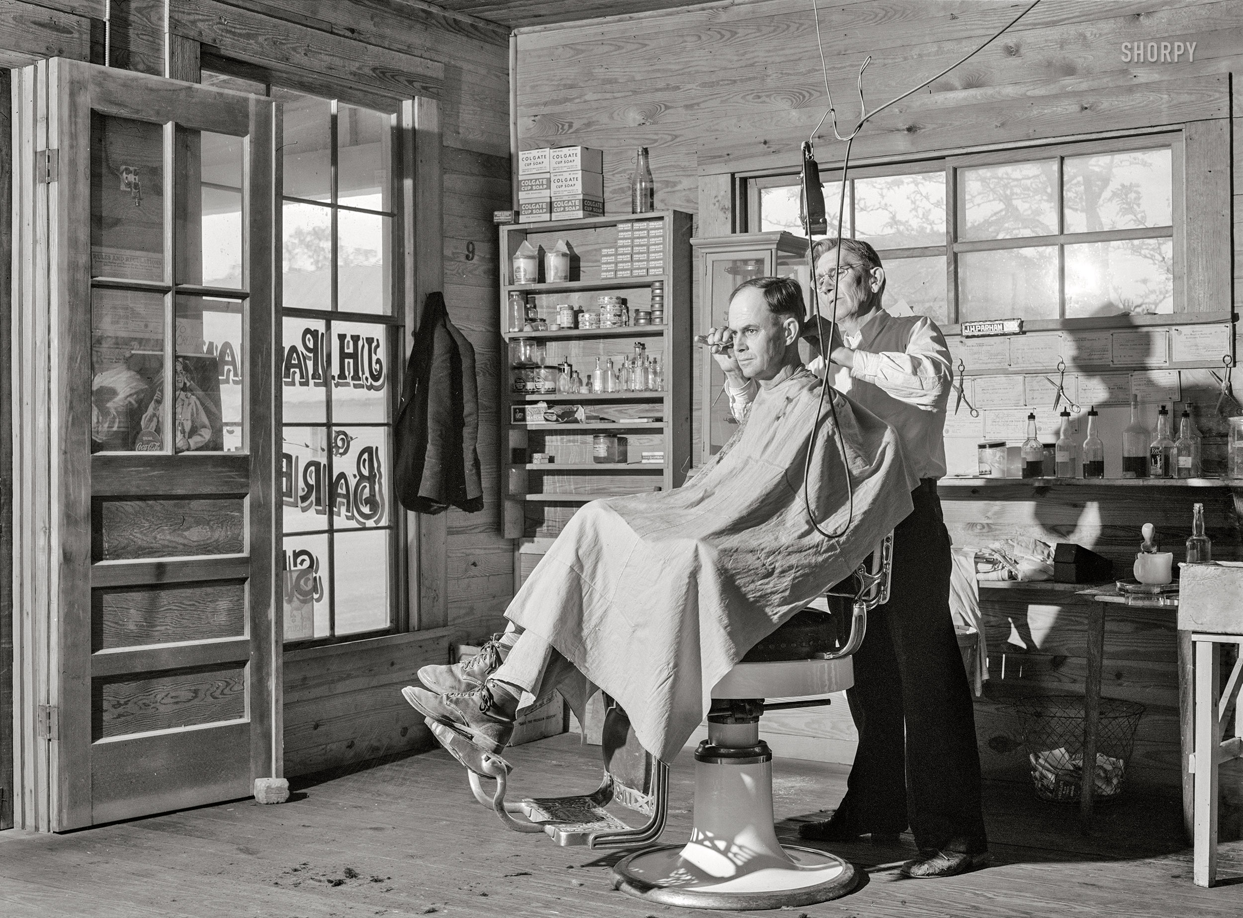 April 1941. "Mr. J. H. Parham, barber and notary public, in his shop in Centralhatchee, Heard County, Georgia." Photo by Jack Delano for the Farm Security Administration. View full size.