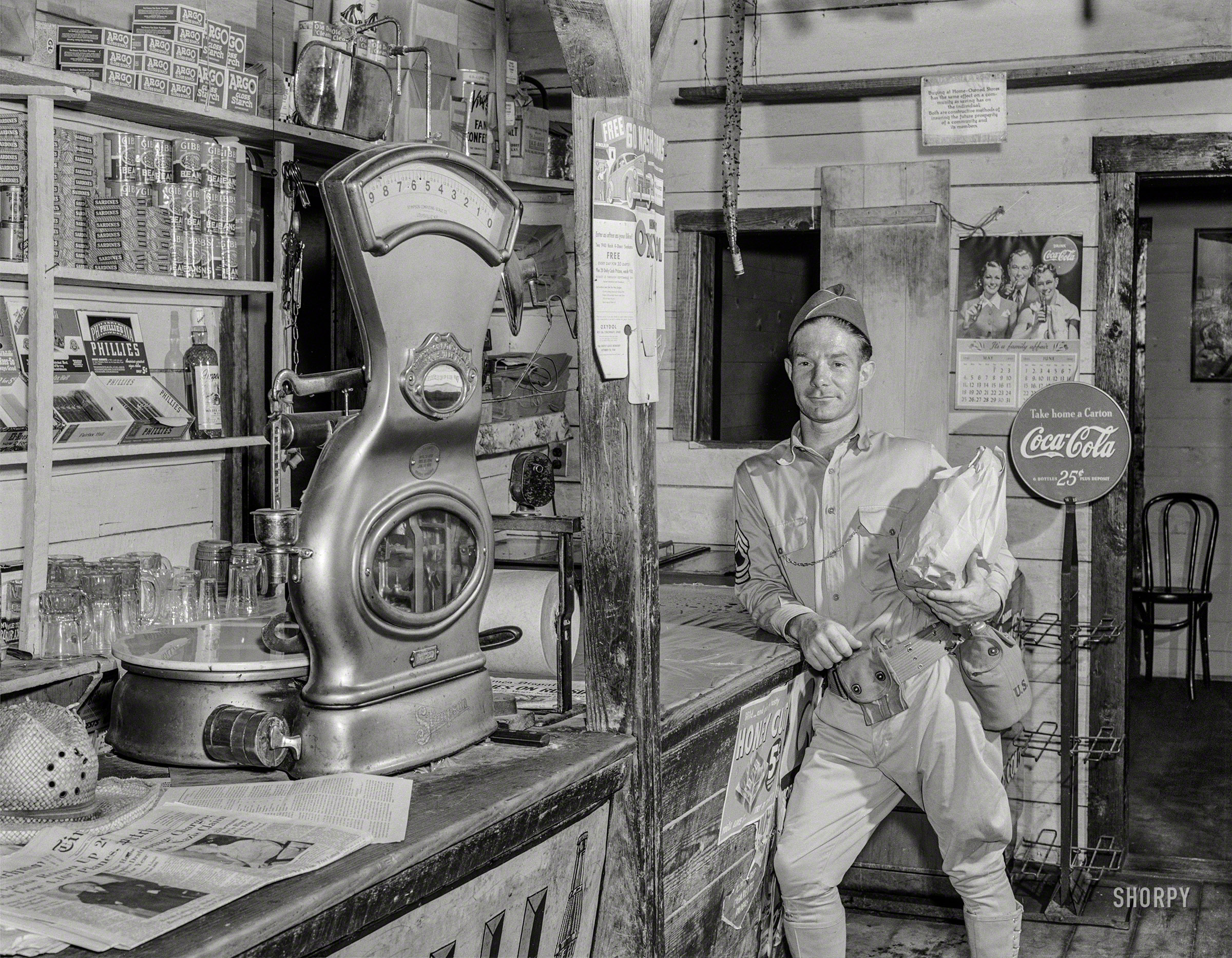 June 1941. "In the area being taken over by the Army -- Caroline County, Virginia. Most of the customers at this store are now soldiers. Many of the people in the area have already moved out and the owners of the store are making plans to move." Medium format acetate negative by Jack Delano. View full size.