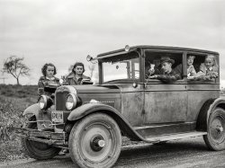 October 1941. "Children of Dan Sampson, who moved out of the Pine Camp expansion area in August, waiting in the family car for the school bus near South Rutland, New York." Medium format negative by Jack Delano. View full size.