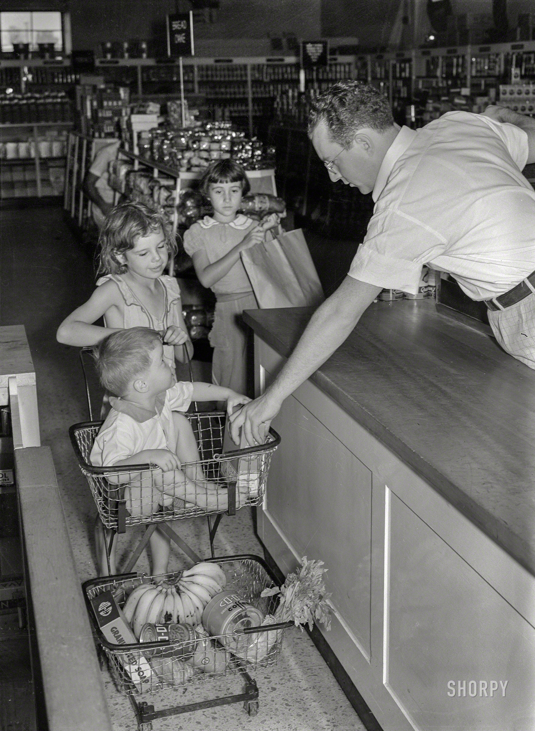 September 1938. "Children of Greenbelt, Maryland, family buying groceries in cooperative store." Acetate negative by Marion Post Wolcott. View full size.