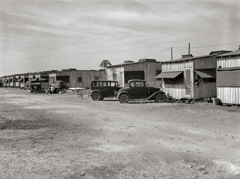 January 1939. "Migratory laborers' camp. Single-room cabin costs $2.50, double room $4 per week. Water hauled, 55 cents for 55-gallon tank. Toilet for about 150 people. Near Belle Glade, Florida." Photo by Marion Post Wolcott, Farm Security Administration. View full size.
