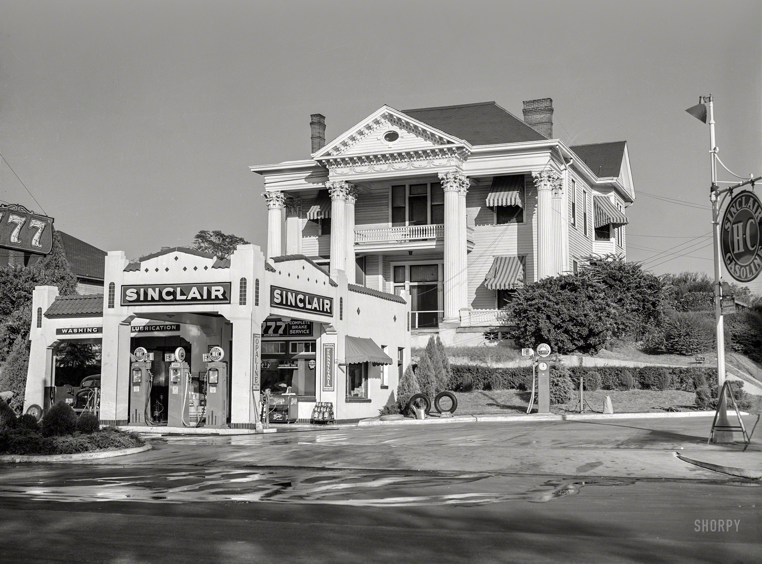November 1939. "Gas station in front of old colonial house (306 North State Street). Jackson, Mississippi Delta." The 777 Service Station, pumping Sinclair "H-C" gasoline. Acetate negative by Marion Post Wolcott. View full size.