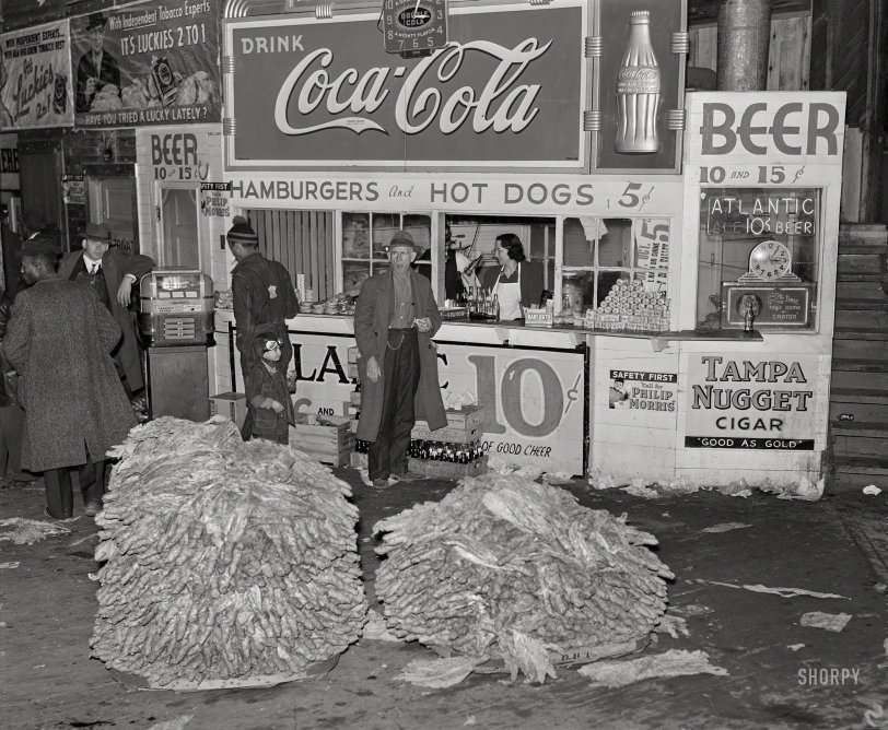 November 1939. "Lunch stand and tobacco inside entrance to warehouse at end of auction sale. Durham, North Carolina." Medium format acetate negative by Marion Post Wolcott for the Farm Security Administration. View full size.
