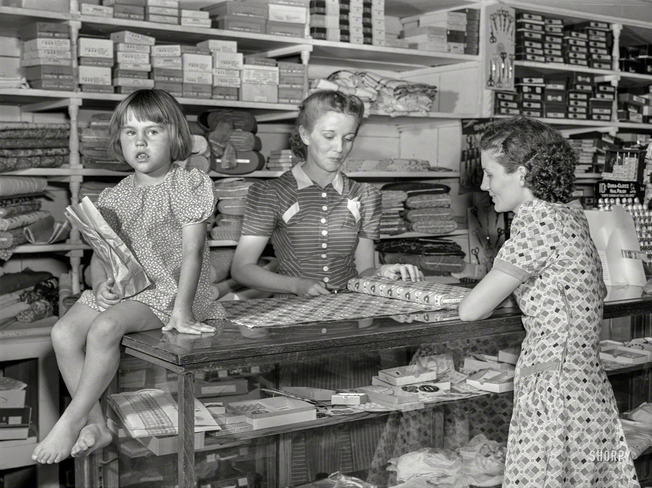 June 1940. "Buying dress goods in project cooperative store. Transylvania Resettlement Project, Louisiana." Medium acetate format negative by Marion Post Wolcott for the Farm Security Administration. View full size.