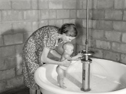 June 1940. Belle Glade, Florida. "Showers for babies, older children and parents, as well as complete laundry facilities, are provided in the utility building for members of the Osceola migratory labor camp." Photo by Marion Post Wolcott for the FSA. View full size.