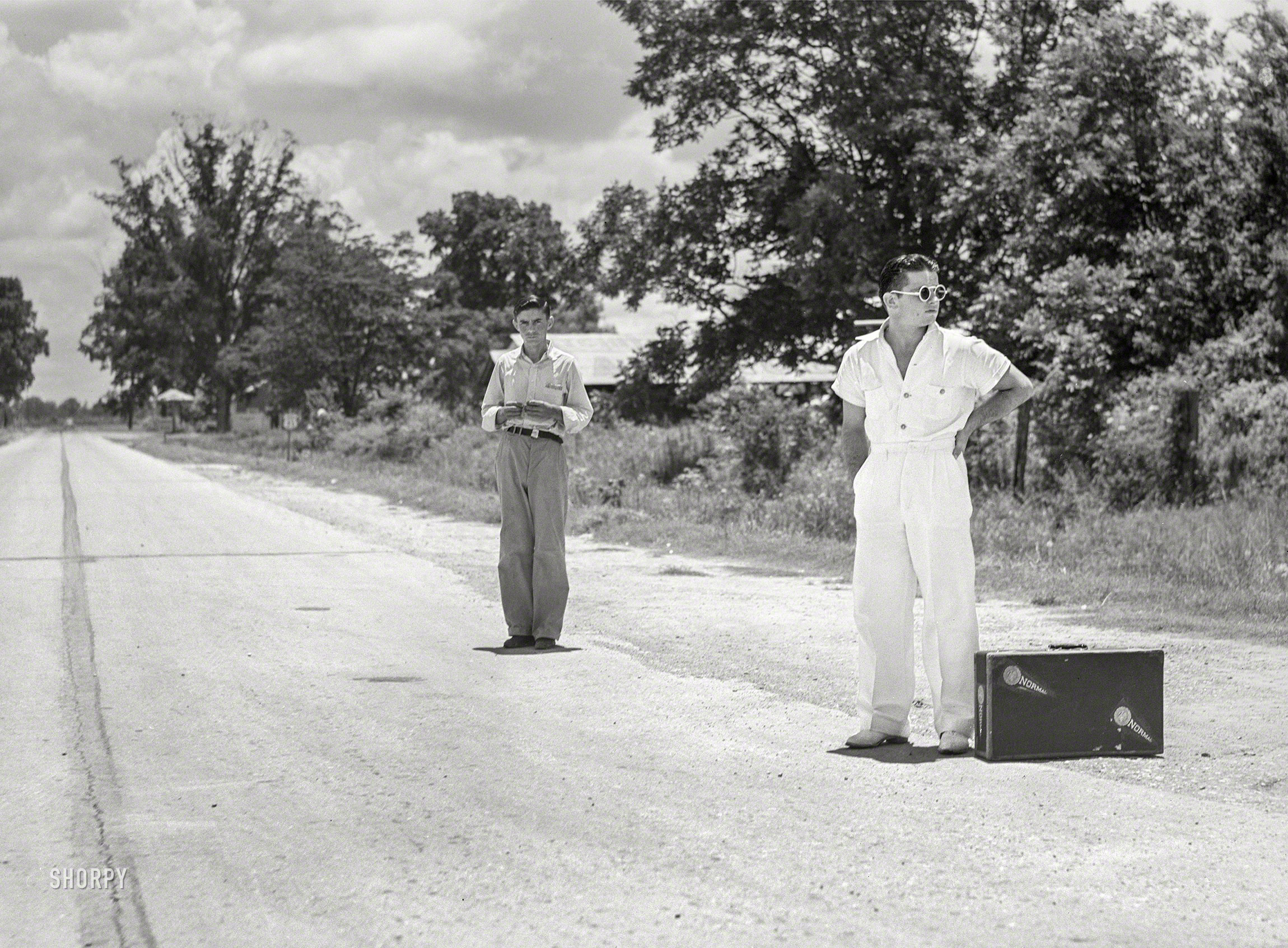 June 1940. "College boy trying to 'thumb' a ride home over the weekend near Natchitoches, Louisiana." Photo by Marion Post Wolcott for the Farm Security Administration. View full size.