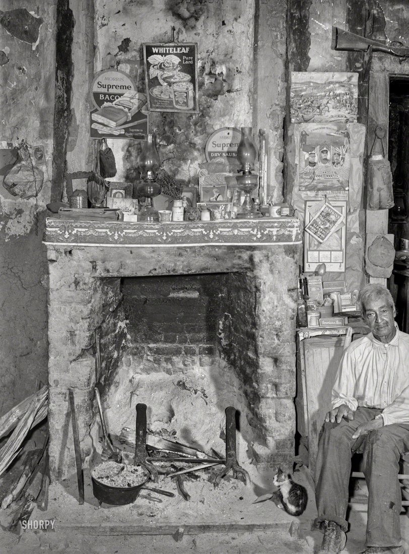 June 1940. "Melrose, Natchitoches Parish, Louisiana. Fireplace in old mud hut built and still lived in by French mulattoes near John Henry cotton plantation. 'Uncle' Joe Rocque, about 86 years old." Photo by Marion Post Wolcott for the Farm Security Administration. View full size.
