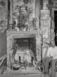 June 1940. "Melrose, Natchitoches Parish, Louisiana. Fireplace in old mud hut built and still lived in by French mulattoes near John Henry cotton plantation. 'Uncle' Joe Rocque, about 86 years old." Photo by Marion Post Wolcott for the Farm Security Administration. View full size.