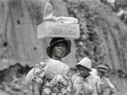 August 1940. "Highway outside Natchez, Mississippi. Negro women carrying bundles of laundry and boxes on their heads." Acetate negative by Marion Post Wolcott. View full size.