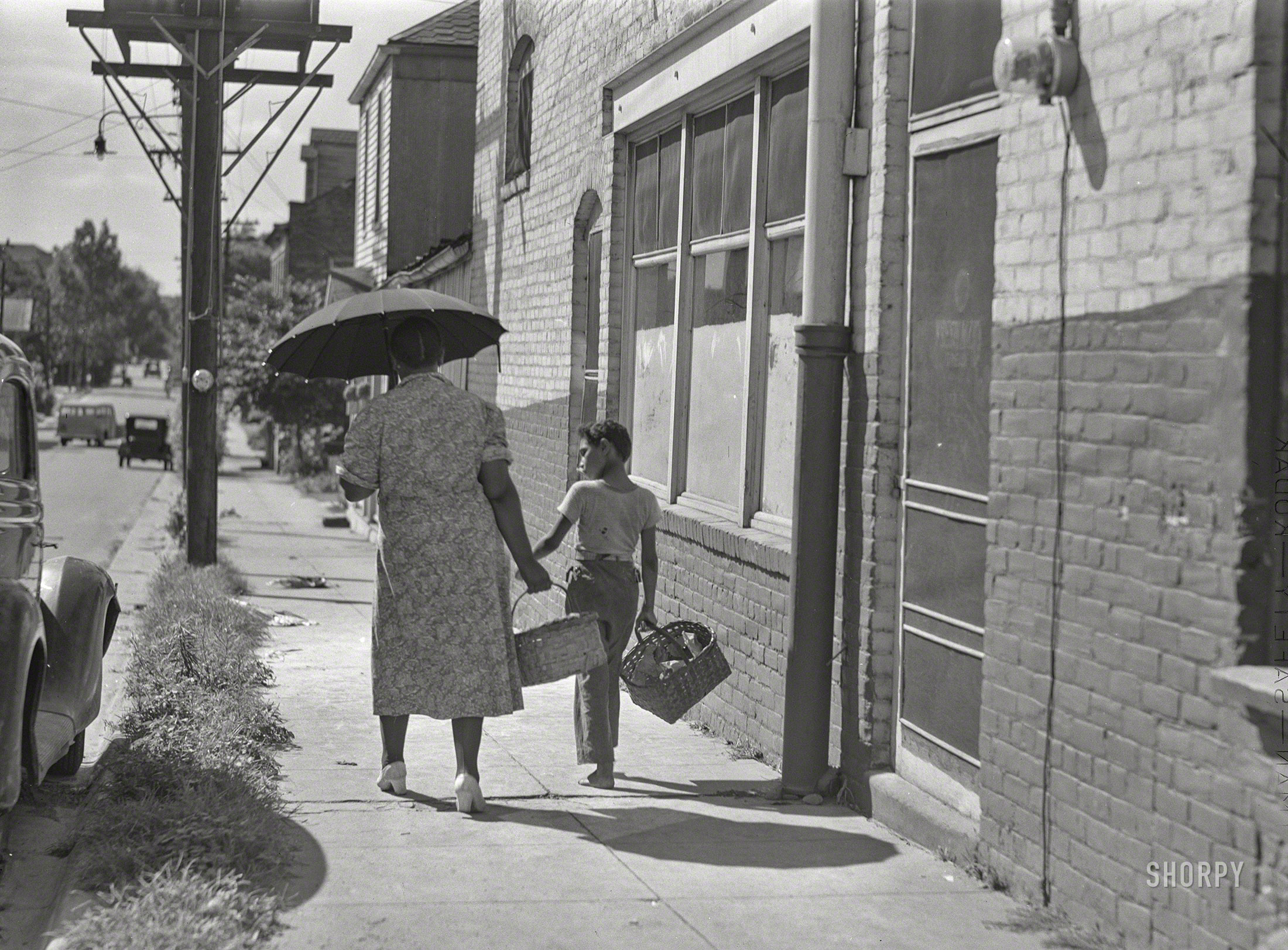 August 1940. "Street scene in Natchez, Mississippi." The duo last seen here. Medium format negative by Marion Post Wolcott for the Farm Security Administration. View full size.