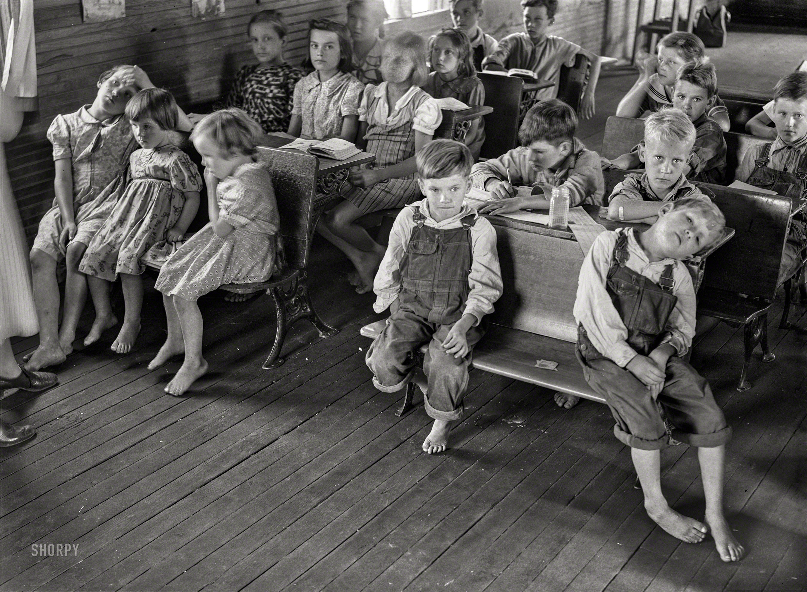 August 1940. "Overcrowded conditions and poor equipment in rural mountain school in Breathitt County, Kentucky. The school year begins in July and ends in January as most of the children have no shoes and insufficient clothing to walk the long distances over bad roads and up creek beds." Medium format negative by Marion Post Wolcott. View full size.