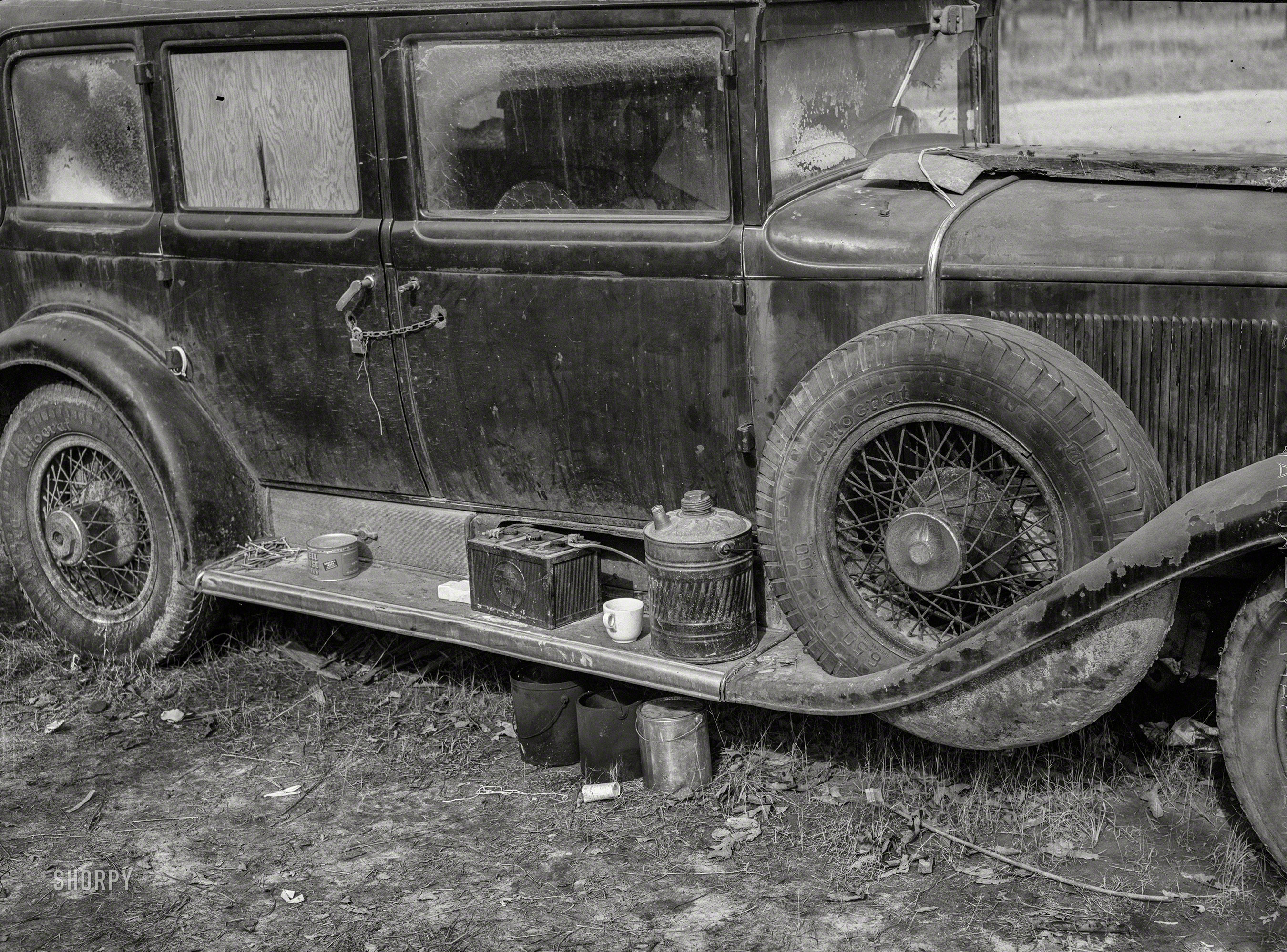December 1940. "Close-up of car from Mississippi used for sleeping as well as shelter and traveling. Evidences of cooking outside are beside it. On highway near Camp Livingston. Alexandria, Louisiana." The battered Cadillac (wearing "Autocrat" tires) seen earlier here. Medium format acetate negative by Marion Post Wolcott. View full size.