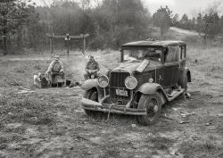 December 1940. First caption: "Close-up of car from Mississippi used for sleeping as well as shelter and traveling. Evidences of cooking outdoors are beside it. On highway near Camp Livingston, Alexandria, Louisiana." Later that day: "Two construction workers who sleep in car, cooking outdoors. One is from Memphis, Tennessee, and worked formerly on construction of the Dupont munitions plant at Millington. The other is from Decatur, Mississippi, and worked previously at the Camp Shelby job in Hattiesburg. He said: 'We live like kings out here. I never did carpenter before I heard you could get paid so much for it; then it didn't take me long to be one.' They are both working on the Camp Livingston job near Alexandria." Medium format negative by Marion Post Wolcott for the Farm Security Administration. View full size.