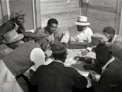 February 1941. "Migratory laborers and vegetable pickers playing a game of 'skin' in back of juke joint and bar in the Belle Glade area of south central Florida." Medium format acetate negative by Marion Post Wolcott. View full size.