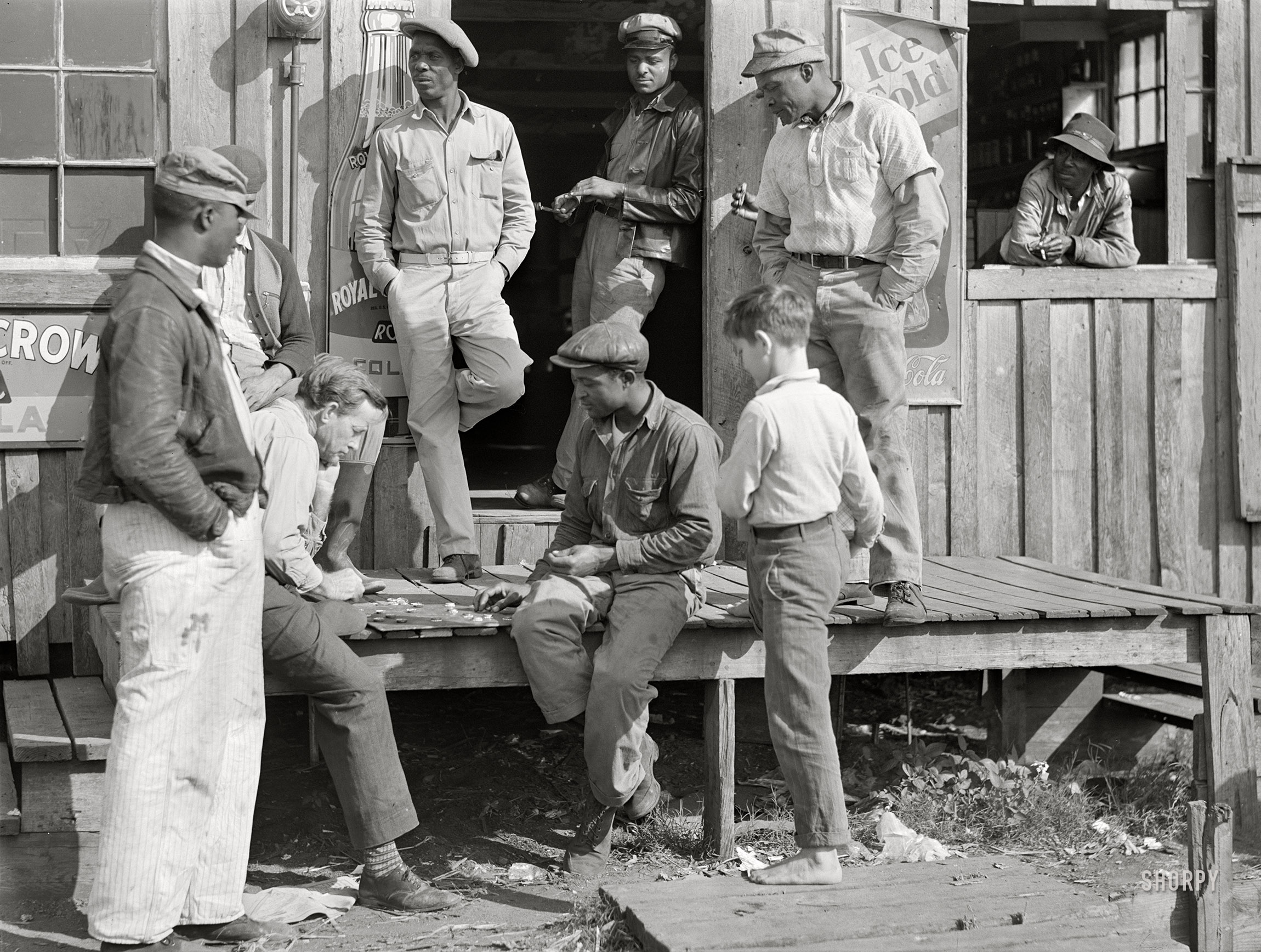 February 1941. Belle Glade, Florida. "Migratory laborers playing checkers in front of juke joint during slack season for vegetable pickers." Medium format acetate negative by Marion Post Wolcott for the Farm Security Administration. View full size.