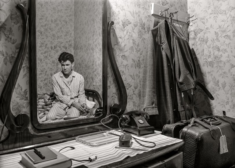 April 1940. Click. Another selfie of photographer John Vachon, last seen here, in the mirror of his Dubuque hotel room in bed in his stripey PJ's. View full size.