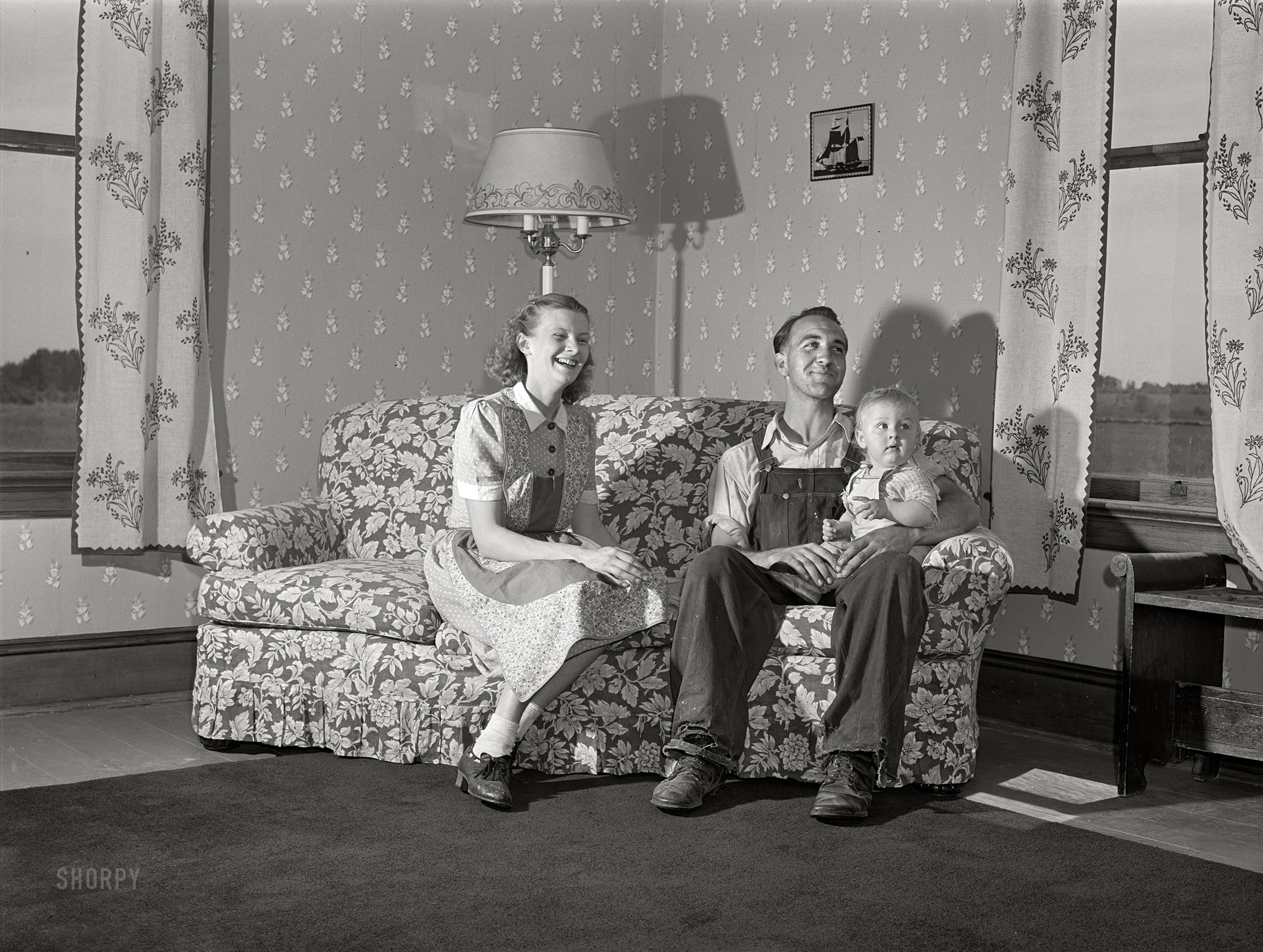 July 1940. Door County, Wisconsin. "Farm Security Administration rehabilitation borrower and family. The wife made the drapes, the chair covers, and papered the wall herself." Medium format negative by John Vachon for the Resettlement Administration. View full size.