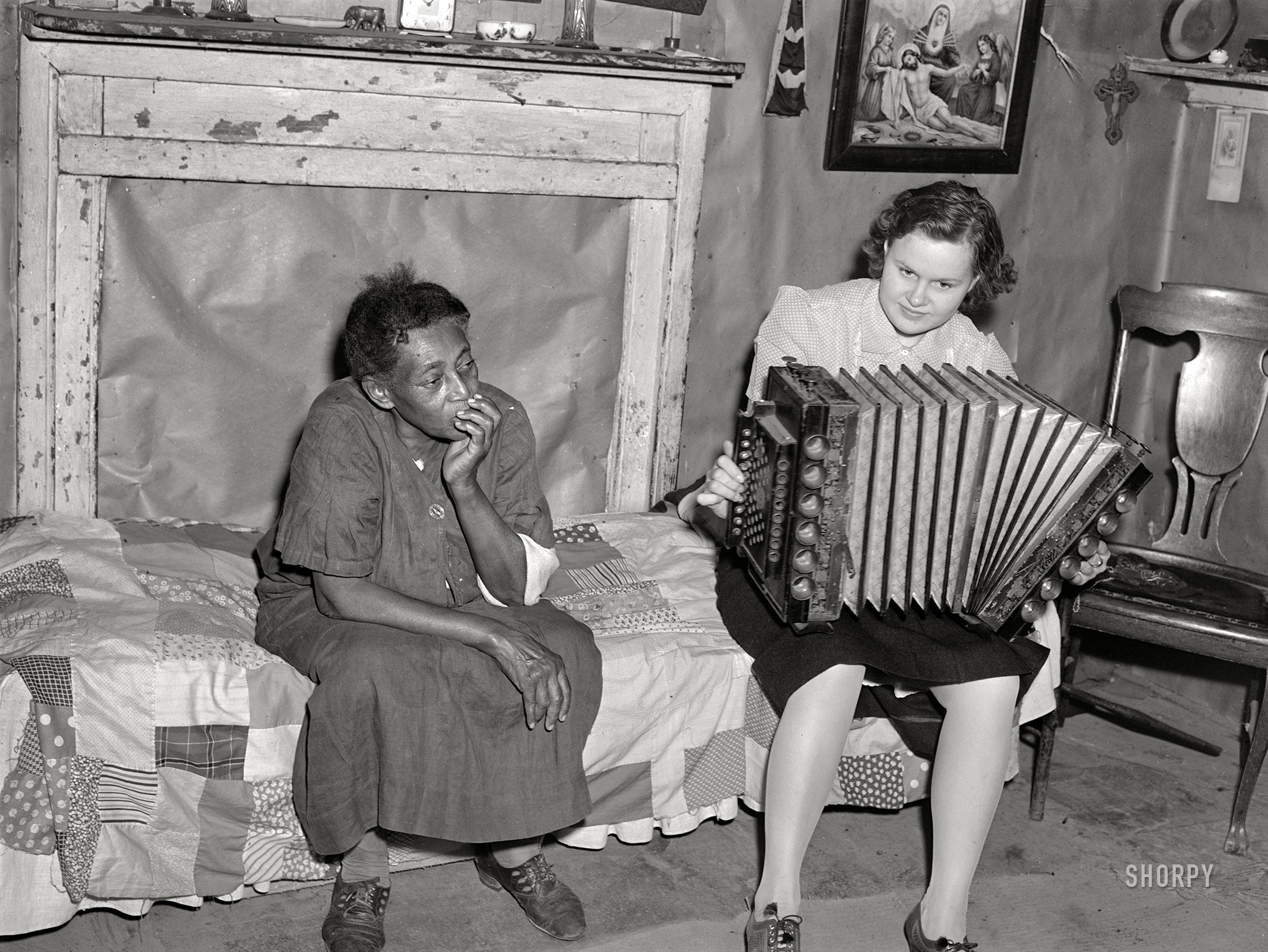 September 1940. St. Mary's County, Maryland. An uncaptioned photo by John Vachon showing Louise Dyson (last seen here with her husband) and unidentified guest playing Mr. Dyson's ancient accordion. Laissez le bon temps rouler! View full size.