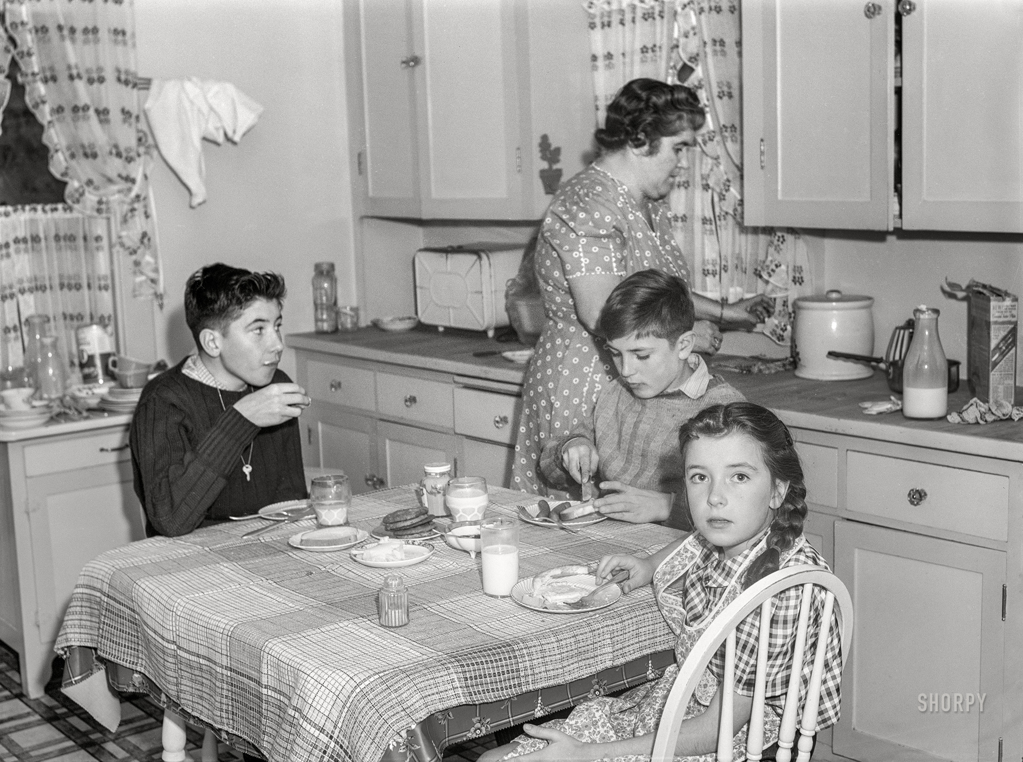 November 1940. Aberdeen, South Dakota. "Mrs. L.M. Schulstad and children in the kitchen. Mr. Schulstad is salesman for a hardware company." Photo by John Vachon. View full size.