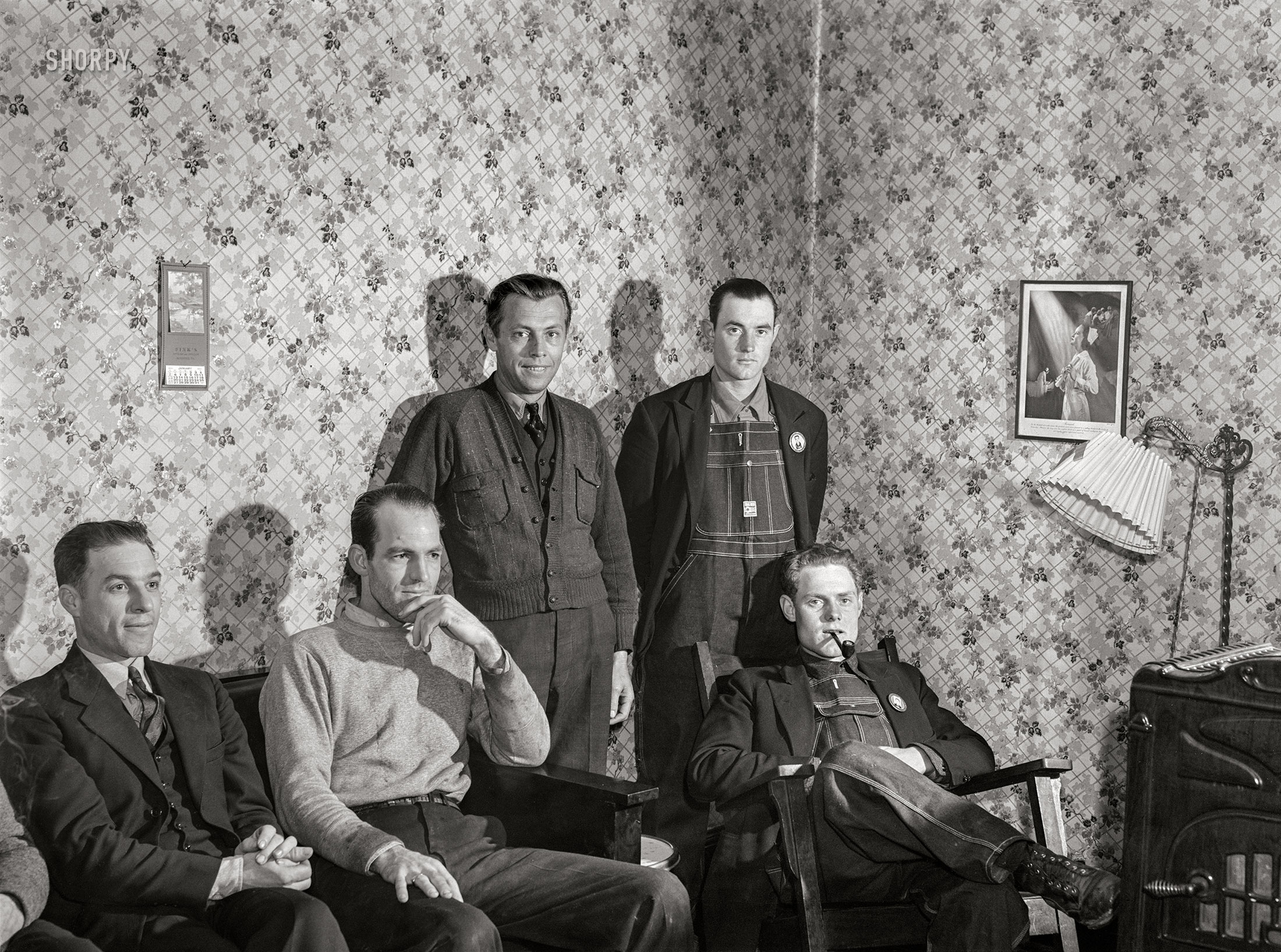 December 1940.  Radford, Virginia. "Influx of construction workers in small town to build Hercules Powder Plant. Five of the boarders at Mrs. Pritchard's house in the parlor. Eighteen men board here." Medium format acetate negative by John Vachon. View full size.