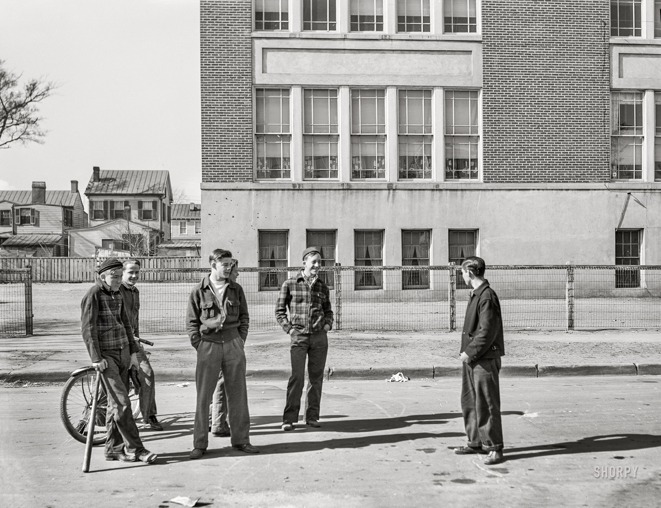 March 1941, somewhere in Virginia. An uncaptioned photo by John Vachon of Navy-town schoolboys shooting the breeze, possibly in Portsmouth. View full size.